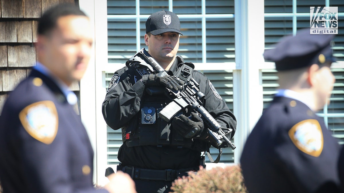 Armed police officers stand guard at the wake of NYPD officer Jonathan Diller