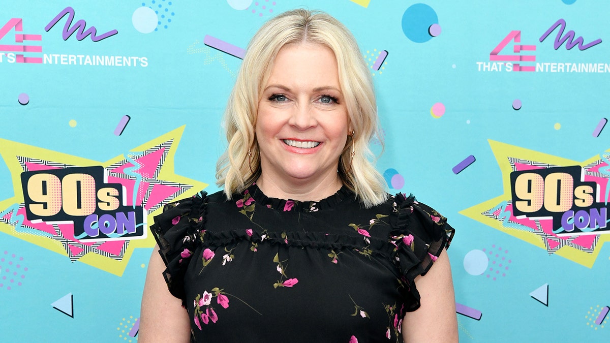 Melissa Joan Hart walks 90sCon red carpet in black floral dress